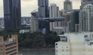 Stebėkite didžiulį karinį lėktuvą, skrendantį tarp pastatų Australijoje